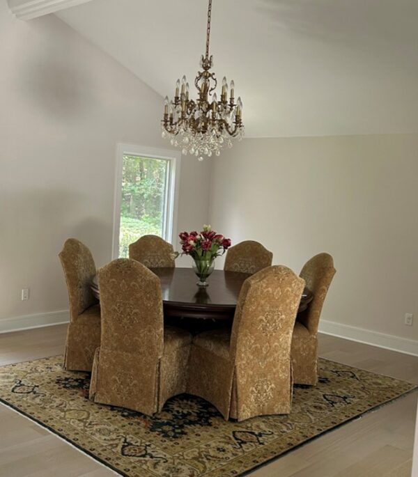 Dining room with gold chairs on a patterned rug.